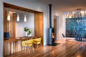 a living room with yellow chairs and a fireplace at Grootbos Private Nature Reserve in Gansbaai