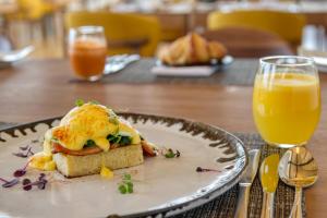 a sandwich on a plate with a glass of orange juice at Grootbos Private Nature Reserve in Gansbaai