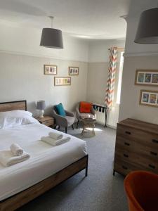 a bedroom with a bed and a chair at Hayward's at the Grasmere in Keynsham