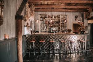 un bar con taburetes en una habitación con techos de madera en Bed and Breakfast de WoerdT, en Altforst