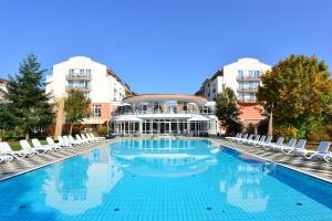 ein großer Pool mit Stühlen und ein Gebäude in der Unterkunft The Monarch Hotel in Bad Gögging