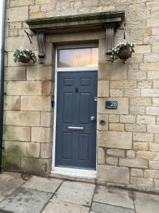 a blue door on a brick building with two plants at 'Bloomfield' at stayBOOM in Lancaster