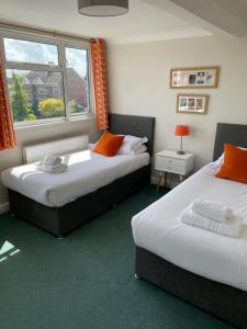 dwa łóżka w pokoju z oknem w obiekcie Hayward's at the Grasmere w mieście Keynsham