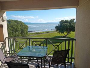 a balcony with a table and chairs and the ocean at Sunset Paradise in Cape Town