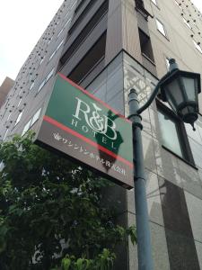 京都市にあるR&B ホテル京都駅八条口の建物の隣の灯りの看板