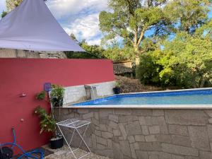 a white umbrella next to a swimming pool at Casa ponto Da Cruz t3 in Arcos de Valdevez
