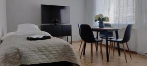 1 dormitorio con 1 cama, mesa y sillas en Niinivaara apartment saunallinen ja ilmastoitu majoitus en Joensuu