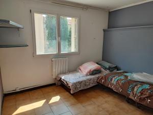 - une chambre avec 2 lits et une fenêtre dans l'établissement Le Planiol, à Saint-Paul-de-Fenouillet