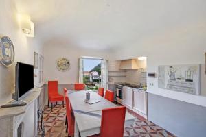 cocina con mesa de comedor y sillas rojas en Trilocale Ginevra, en Finale Ligure