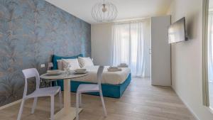 um quarto com uma cama, uma mesa e cadeiras em Italianway - The B Village New em Milão