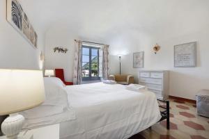 1 dormitorio con cama blanca y ventana en Trilocale Ginevra, en Finale Ligure