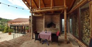 d'une terrasse avec une table, des chaises et une cheminée. dans l'établissement Guest House Marani, à Sighnaghi