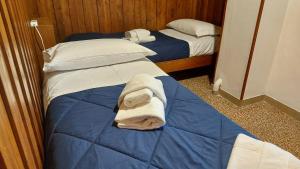维罗纳Mansarda Romantica的房间里有两张床，上面铺着毛巾。