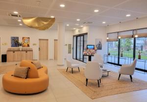 - une salle d'attente dans un hôpital avec un canapé et des chaises dans l'établissement Residhome Nice Aéroport, à Nice