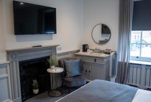 ein Schlafzimmer mit einem Kamin und einem TV an der Wand in der Unterkunft J.D.Young in Harleston