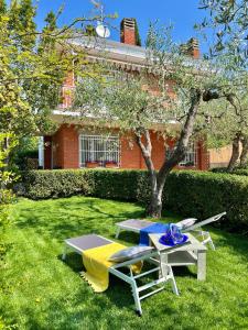 une table de pique-nique et un banc dans l'herbe devant un bâtiment dans l'établissement Villa La Rodina, à Diano Marina