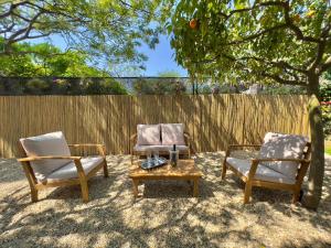 2 chaises et une table basse en face d'une clôture dans l'établissement Villa La Rodina, à Diano Marina