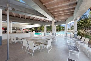 um pátio com uma mesa e cadeiras e uma piscina em Ethra Reserve Alborèa em Castellaneta Marina