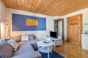 a living room with a couch and a table with a tv at Denkerhof Ferienwohnung Sodalith in Reußenköge