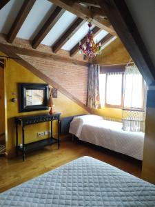 una camera mansardata con 2 letti e un lampadario a braccio di Camino a Casa - Suances a Hinojedo