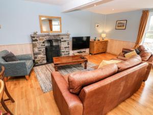 a living room with a couch and a fireplace at Glan y Mor in Haverfordwest