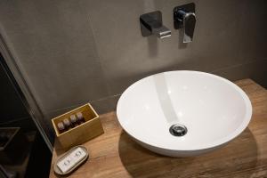 a white sink in a bathroom with a remote control at City Gallery Apartments in Trieste +37 photos