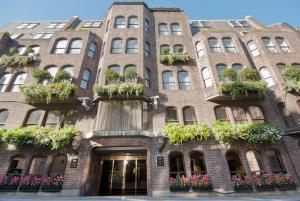 a brick building with potted plants on it at Mayfair House in London