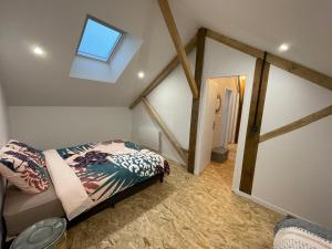 ein Schlafzimmer mit einem Bett in einem Zimmer mit einem Fenster in der Unterkunft Gîte moulin de Chaussac proche du Puy duFou in Saint-Laurent-sur-Sèvre
