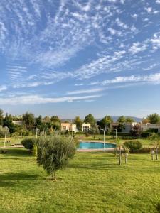 un campo verde con una piscina en el medio en Résidence du golf en Fez