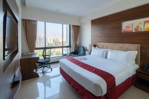 a hotel room with a bed and a large window at Hotel Tip Top International Pune in Pune