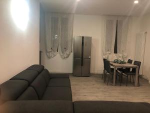 a living room with a couch and a table and a refrigerator at SweetHome in Lissone
