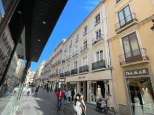 een groep mensen die door een straat met gebouwen lopen bij Apartamento Centro Alhóndiga Suite in Granada