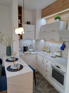 a kitchen with white cabinets and a sink at Apartman Rojić in Novi Sad