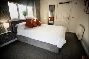 1 dormitorio con 1 cama blanca grande con almohadas rojas en The Dwelling Place, en Irvine
