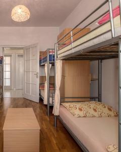 a bedroom with two bunk beds and a table at Hostel Split Backpackers in Split