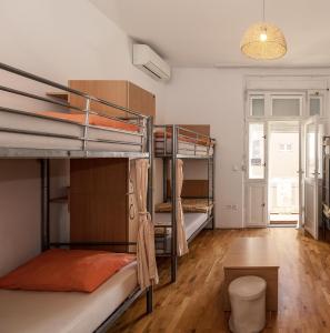 a room with three bunk beds and a table at Hostel Split Backpackers in Split