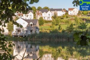 une grande maison au bord d'un lac dans l'établissement Village Pierre & Vacances Normandy Garden, à Branville