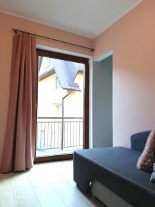 Pokój z dużym oknem, łóżkiem i balkonem w obiekcie Willa pod Aniołem w mieście Szczawnica