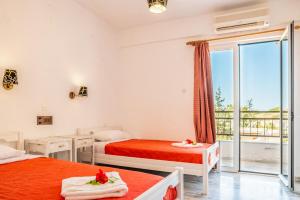 a bedroom with two beds and a balcony at Matala Hostel in Matala +40 photos