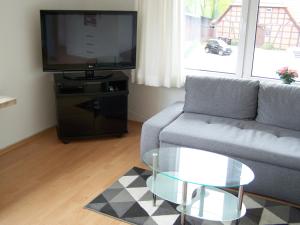 a living room with a couch and a tv at Hostel Wendt in Fintel