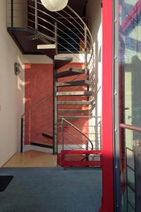 a metal spiral staircase in a building with a red door at Ferienwohnungen Familie Lang in Pirna