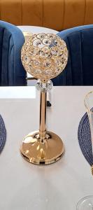 a gold wine glass on a white table at Apartman Rojić in Novi Sad