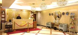 a man standing behind a counter in a salon at Asherij Hotel in Doha