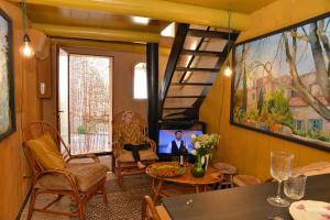 a living room with a tv and a table and chairs at La BARBELLA in Lourmarin