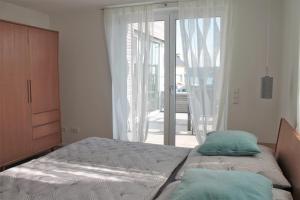 um quarto com uma cama e uma porta de vidro deslizante em REBHAUS Ferienwohnung Weinlaube em Sipplingen