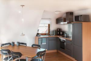 a kitchen with a wooden table and a table and chairs at OBSTHAUS Ferienwohnung Apfel in Sipplingen