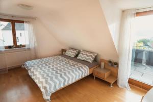 a bedroom with a bed and a large window at OBSTHAUS Ferienwohnung Apfel in Sipplingen