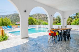 a dining room with a table and a swimming pool at Matala Hostel in Matala