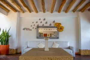 a table in a room with a couch and a mirror at Hotel Victoria Barichara in Barichara