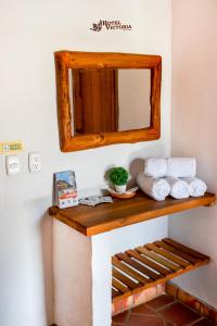 a mirror on a wall above a shelf with towels at Hotel Victoria Barichara in Barichara